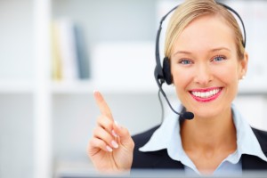 Young receptionist with headset pointing towards copyspace